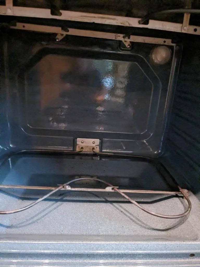 Oven interior with leftover dirt and residue, showing the work involved in post-construction cleaning