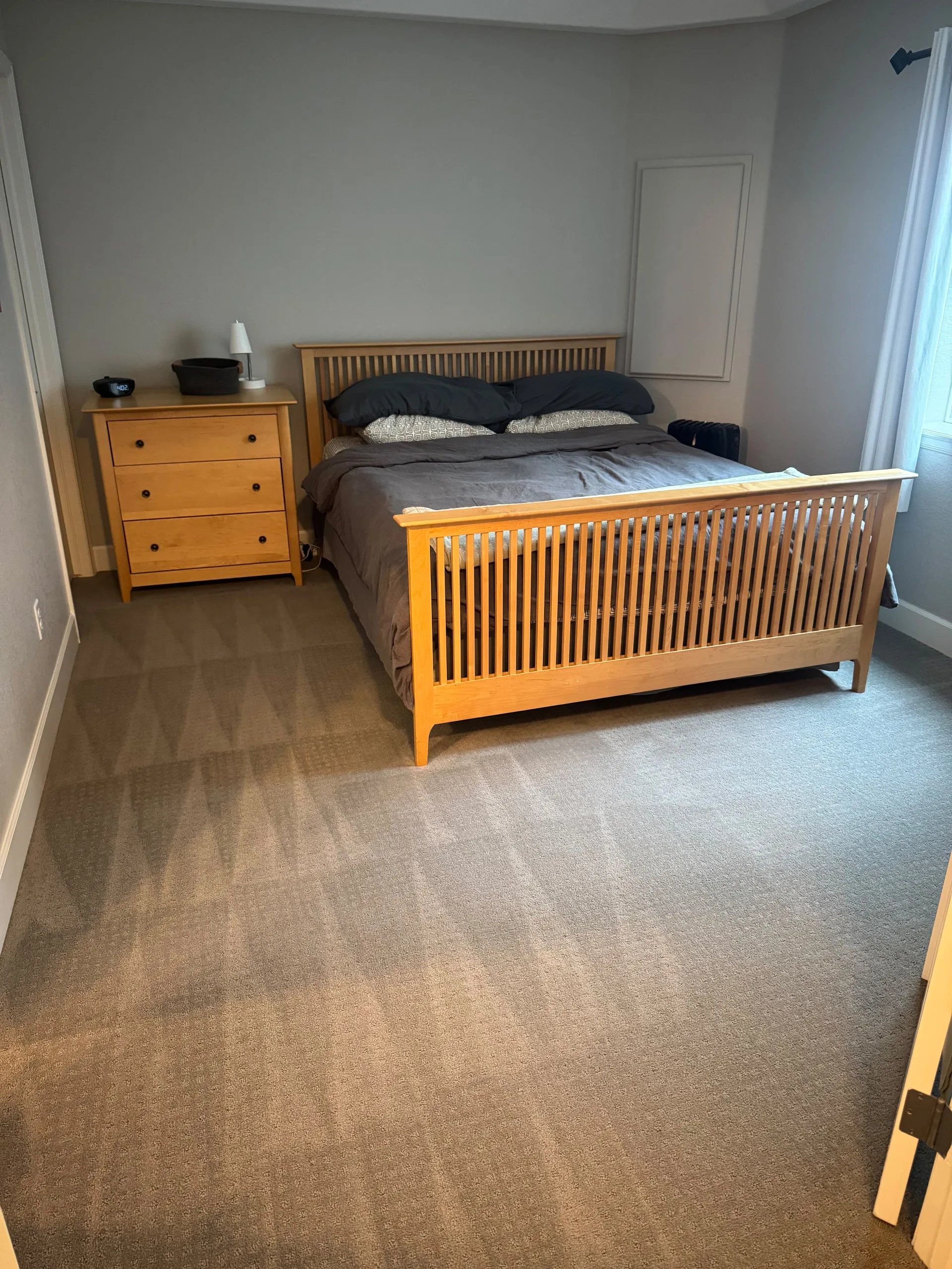 Tidy, freshly cleaned bedroom with fresh vacuum lines on the carpet